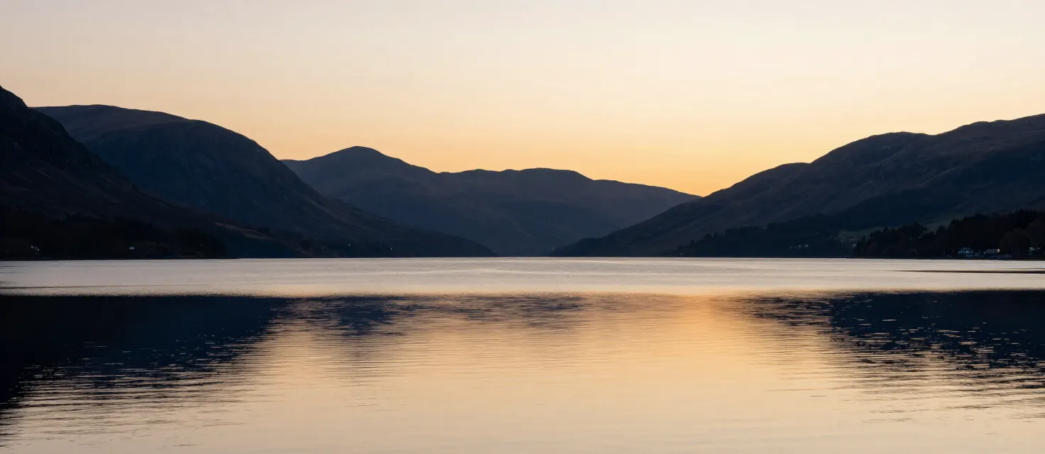 A calm loch surrounded by hills